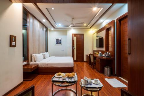 een hotelkamer met een bed en een tafel met eten bij Hotel Grand FFOUR in New Delhi