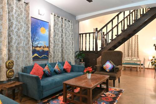 a living room with a blue couch and two chairs at GR STAYs Private Pool Villa in Calangute 5 mins to Baga in Arpora