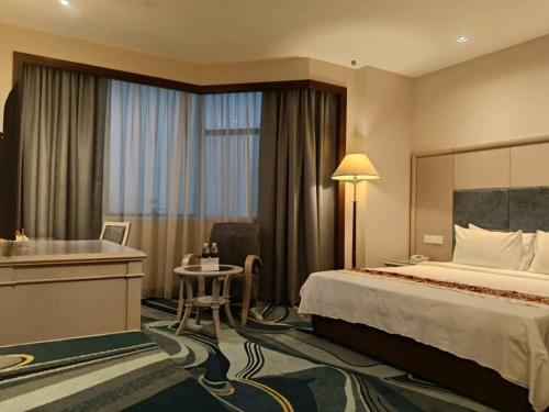 ミリにあるインペリアル ホテル ミリのベッドと机があるホテルの部屋