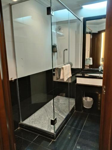 a glass shower in a bathroom with a sink at Imperial Hotel Miri in Miri