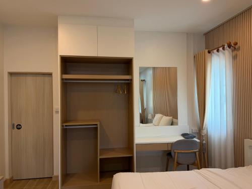 a bedroom with a bed and a desk and a mirror at เพชรไพลินรีสอร์ทสามร้อยยอด in Sathani Sam Roi Yot