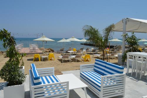 a group of chairs and tables on a beach at Island Boutique Hotel in Larnaka