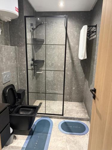 a bathroom with a shower with a black toilet at Metropoleparc luxury apparthotel in Casablanca