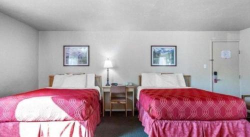 a hotel room with two beds and a desk at Econo Lodge Inn & Suites in Durango