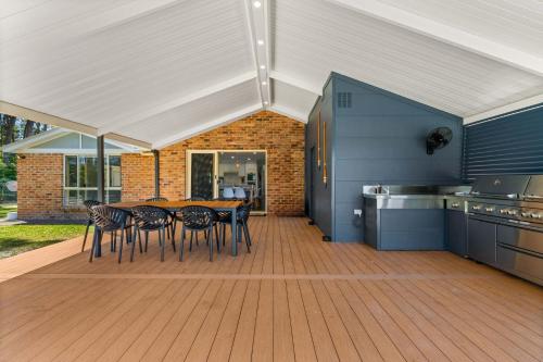 eine Küche mit Tisch und Stühlen auf einer Terrasse in der Unterkunft The Quay To Sussex in Sussex inlet