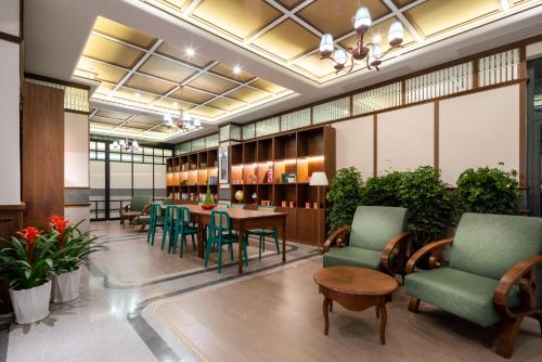 a library with green chairs and a table and chairs at A Memory Hotel Beijing Daxing in the Garden 时光赞歌花园酒店北京大兴王府井奥莱店 Free fresh ground coffee,Free laundry service in Beijing
