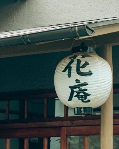 a lantern with asian writing on it hanging on a door at Hostel Hana An in Tokyo