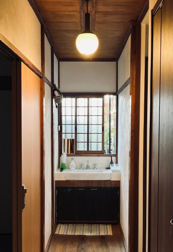 a bathroom with a sink and a large window at Hostel Hana An in Tokyo