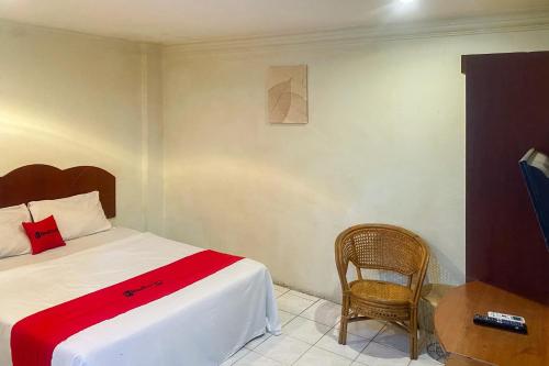 un dormitorio con una cama y una silla en RedDoorz at Hotel Memory Batam, en Jodoh