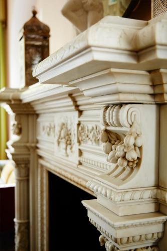 a white fireplace with flowers on top of it at Bromley Court Hotel London in Bromley