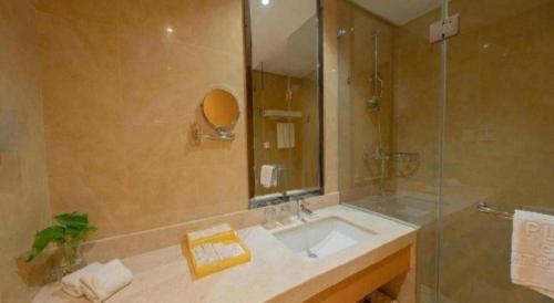 a bathroom with a sink and a shower at Ramada Plaza by Wyndham Chuzhou in Chuzhou