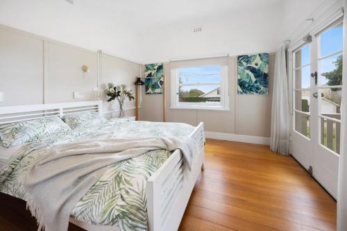 a white bedroom with a large bed and a window at BEACHSIDE GETAWAY DROMANA in Dromana