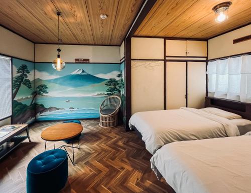 a room with two beds and a table at Hostel Hana An in Tokyo