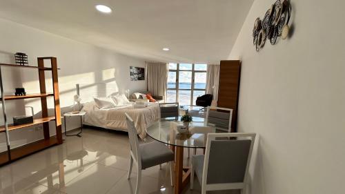 a room with a bed and a table and a bedroom at Edificio La Rue- frente al mar in Piriápolis