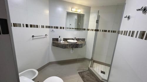 a bathroom with a shower and a sink and a toilet at Edificio La Rue- frente al mar in Piriápolis
