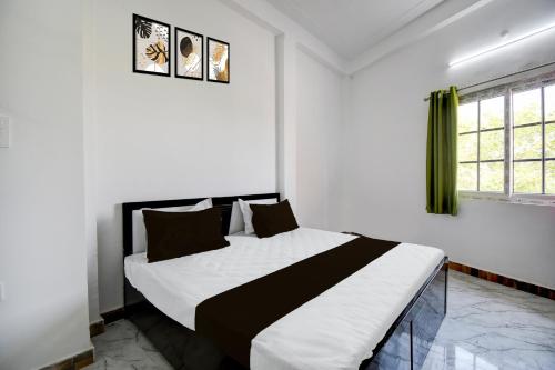 Un dormitorio con una cama en blanco y negro y una ventana. en SPOT ON Hotel Gold Inn, en Bheta