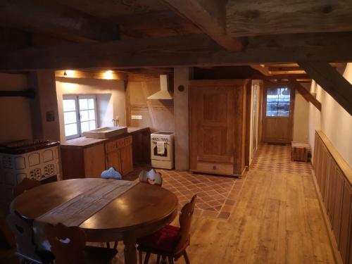 a kitchen with a wooden table and a wooden floor at Gite de traditions et charme Chez Montze in Hoerdt