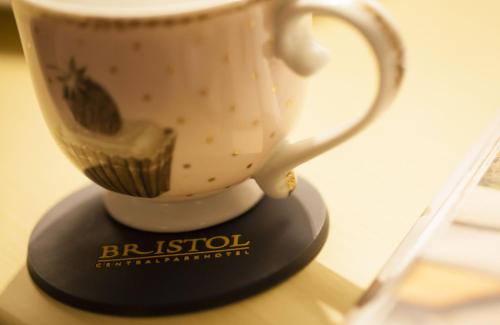 a coffee cup sitting on top of a table at Bristol Central Park Hotel in Chişinău