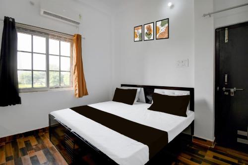 1 dormitorio con 1 cama con sábanas blancas y negras en SPOT ON Hotel Gold Inn, en Bheta