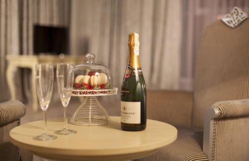 a bottle of champagne and two wine glasses on a table at Bristol Central Park Hotel in Chişinău