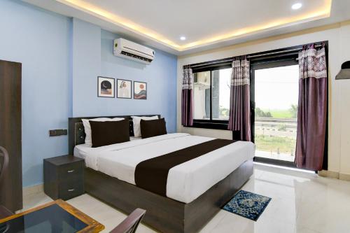 a bedroom with a large bed and a window at Hotel O S-Square in Bhadrak