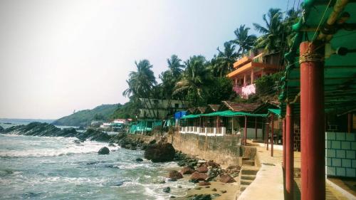 a view of a beach with a building and the ocean at Ludu guest house in Arambol