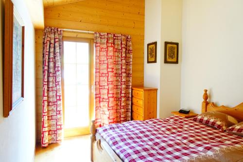 Schlafzimmer mit einem Bett und einem Fenster in der Unterkunft Sweet Mountain in Les Diablerets