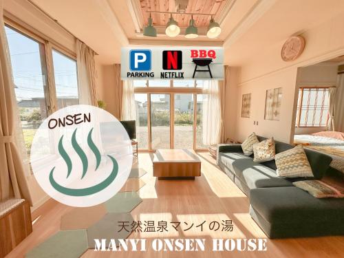 a living room with a green couch and a mannt emission house at リニューアル天然温泉マンイの湯 in Shiraoi