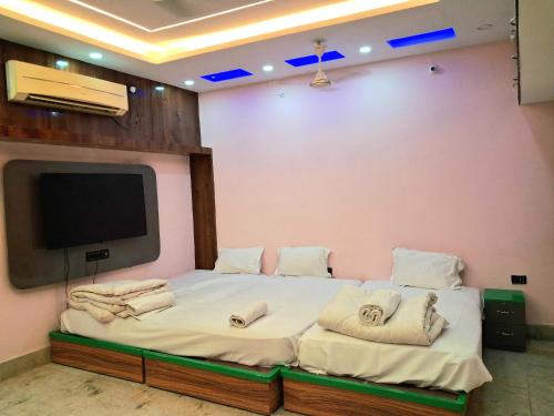a room with a bed with a flat screen tv at Hotel O Raj Mahal INN in Gulzārbāgh