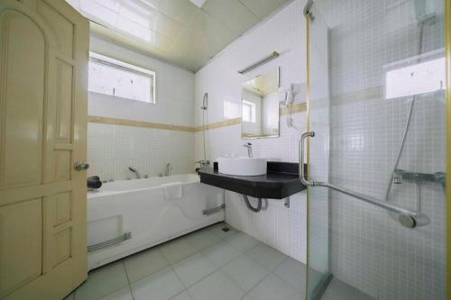 ハイフォンにあるClassic Hoang Long Hotelの浴槽と洗面台とバスタブを備えたバスルーム