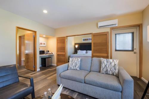 a living room with a couch and a bed at Inn at Port Gardner-Everett Waterfront, Ascend Hotel Collection in Everett