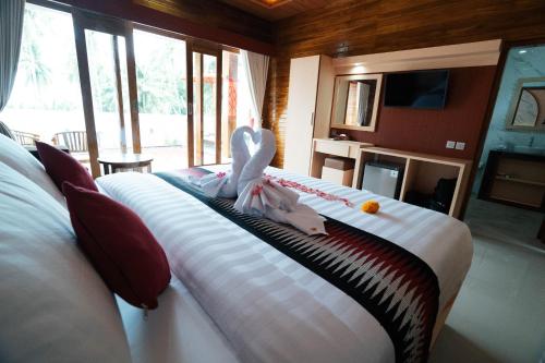 SampalanにあるVarigata Private Villa Nusa Penidaの白いシーツが敷かれた大きなベッドのある寝室