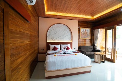 SampalanにあるVarigata Private Villa Nusa Penidaのベッドと椅子のある寝室