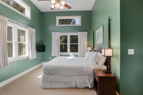 a green bedroom with a bed and two windows at The Palmer House Resort, an Ascend Collection Hotel in Manchester