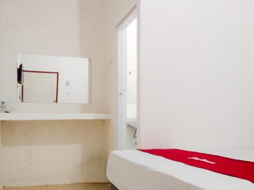 a white bedroom with a bed and a window at RedDoorz near Juwata 3 Airport Tarakan in Karanganyar
