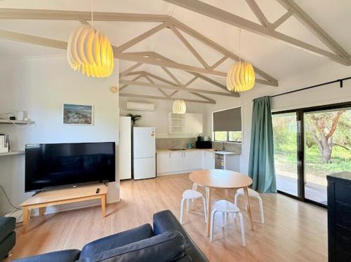 a living room with a couch and a table at Beachside Cabin No 1 at Island Beach in Island Beach
