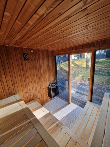 Habitación grande de madera con cama y ventana en Treehouses, en Skorochow