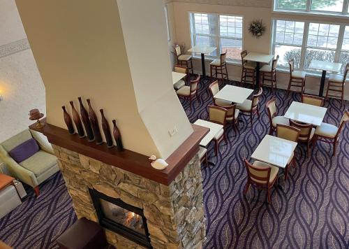 a waiting room with a fireplace and a bar at Smart Suites, an Ascend Collection Hotel in Burlington