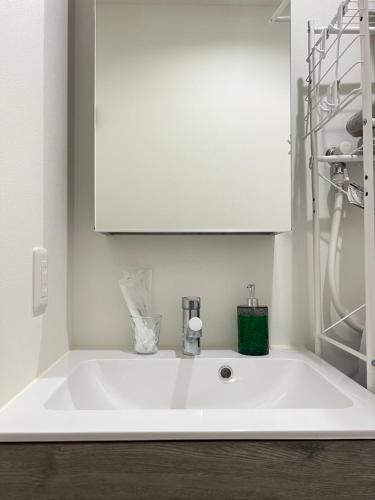 a white sink in a bathroom with a cabinet at ブレイブベース糸島 in Itoshima