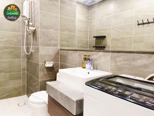 a bathroom with a white sink and a shower at Bell Suites by Salaam Suites, Sepang in Sepang