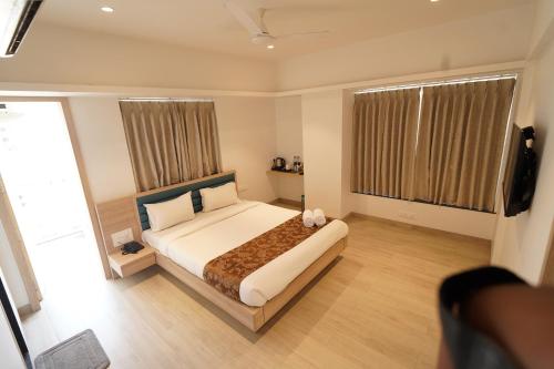 une chambre avec un lit et une grande fenêtre dans l'établissement Excellent Homes, à Nashik