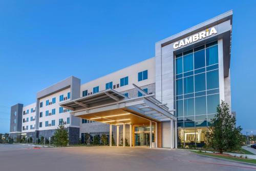 a large building with a car dealership at Cambria Hotel Waco University Riverfront in Waco