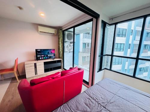 a red couch in a room with a large window at Centrio nearby Central Phuket in Phuket