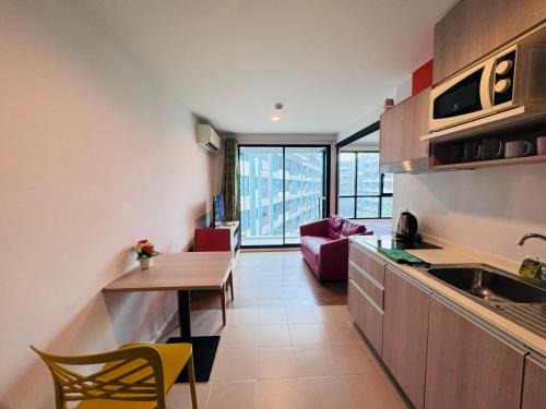 a kitchen and living room with a table and chairs at Centrio nearby Central Phuket in Phuket