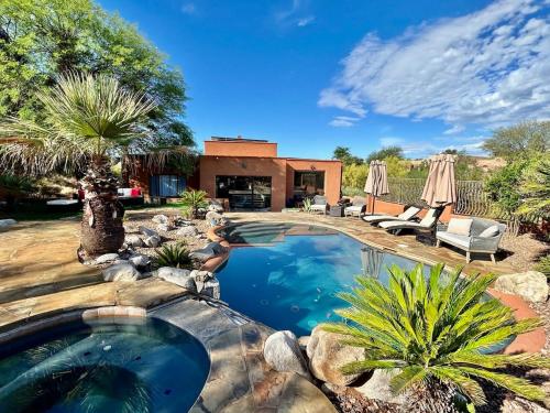 a swimming pool in a yard with palm trees at Casa Catalina - Luxury Desert Oasis in Tucson
