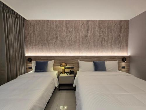 two beds sitting next to each other in a room at Fun Stay Inn Hanzhong in Taipei