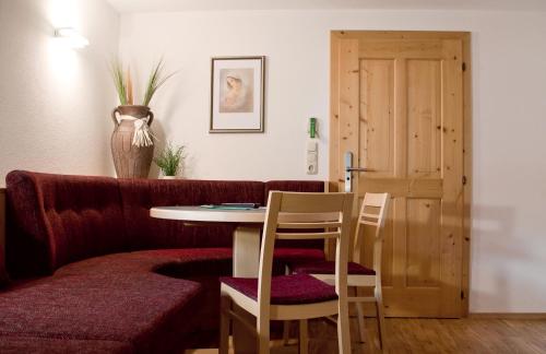 a living room with a couch and a table and chairs at Hotel & Suites Glück Auf in Mayrhofen