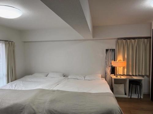 a bedroom with a white bed and a lamp at 板橋 RCアネックス Rc206 in Tokyo