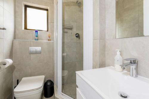 a bathroom with a shower and a toilet and a sink at 39 Kingston in Ballito