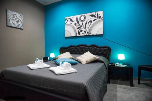 ein Schlafzimmer mit zwei Handtüchern auf einem Bett mit blauer Wand in der Unterkunft Costantino Secondo Guest House in Rom
